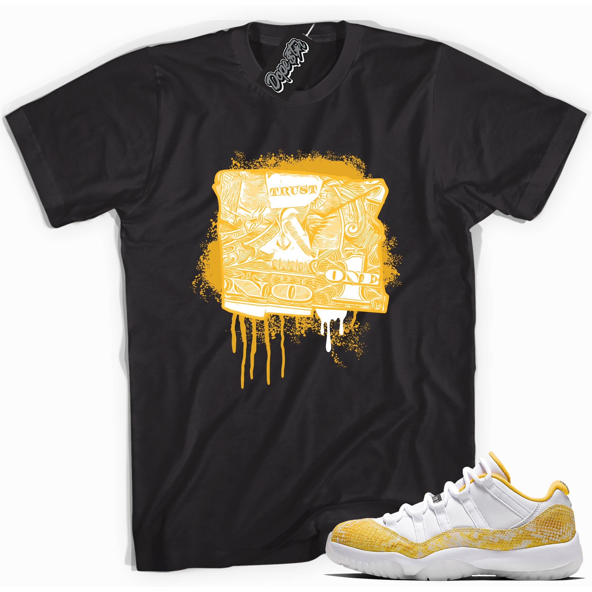 Cool black graphic tee with 'trust no one dollar bill' print, that perfectly matches Air Jordan 11 Retro Low Yellow Snakeskin sneakers