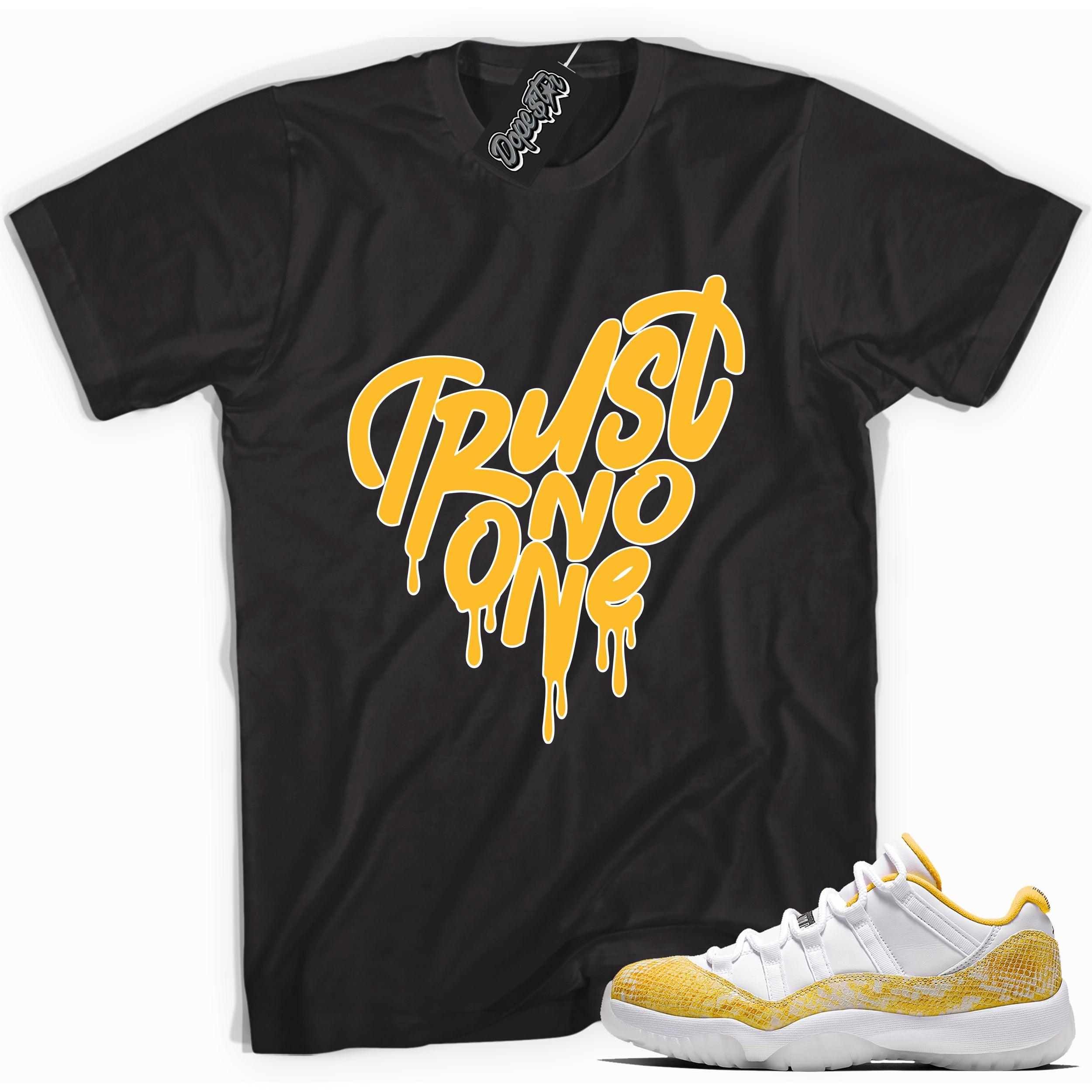 Cool black graphic tee with 'trust no one' print, that perfectly matches Air Jordan 11 Retro Low Yellow Snakeskin sneakers
