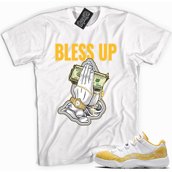 Cool white graphic tee with 'bless up' print, that perfectly matches Air Jordan 11 Retro Low Yellow Snakeskin sneakers