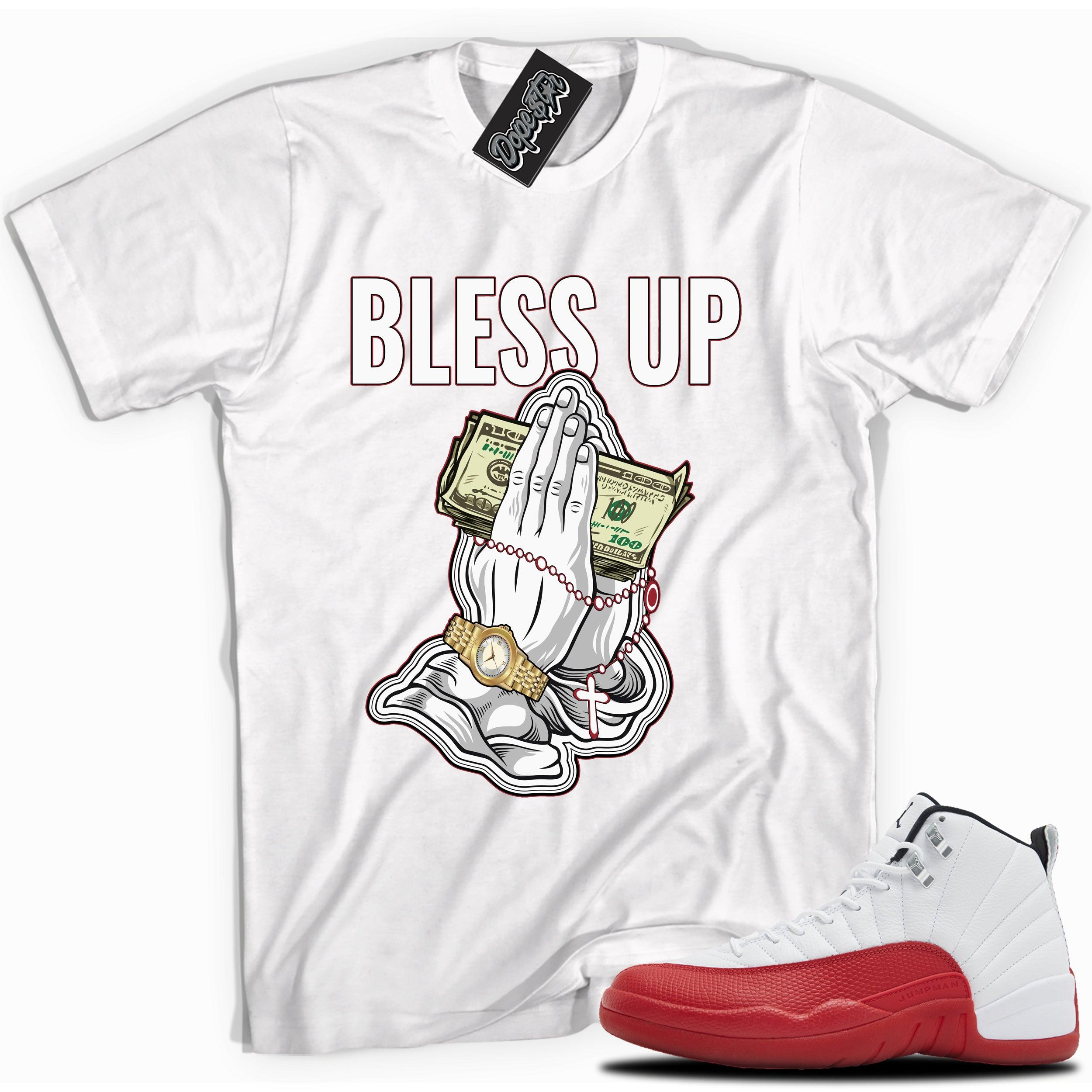 Cool White graphic tee with “ Bless Up ” print, that perfectly matches Air Jordan 12 Retro Cherry Red 2023 red and white sneakers 