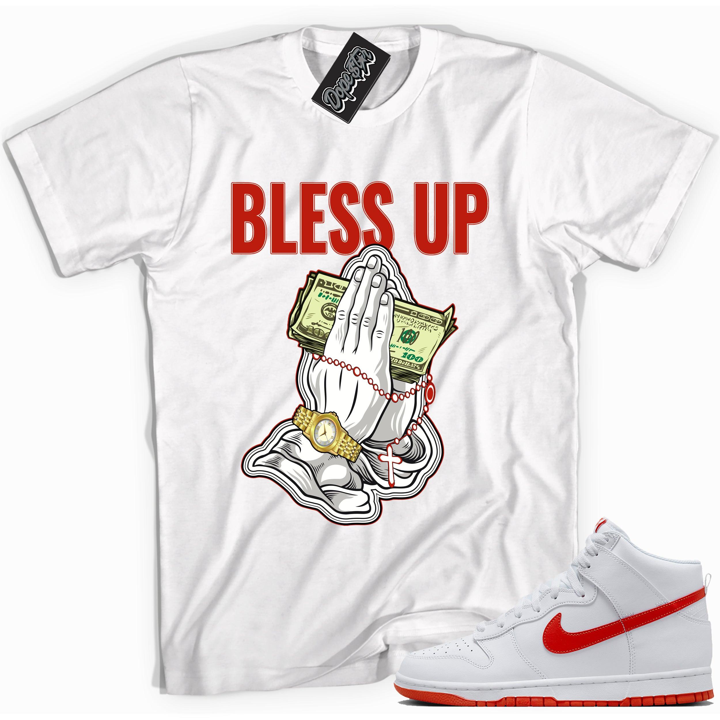 Cool white graphic tee with 'bless up praying hands' print, that perfectly matches Nike Dunk High White Picante Red sneakers.