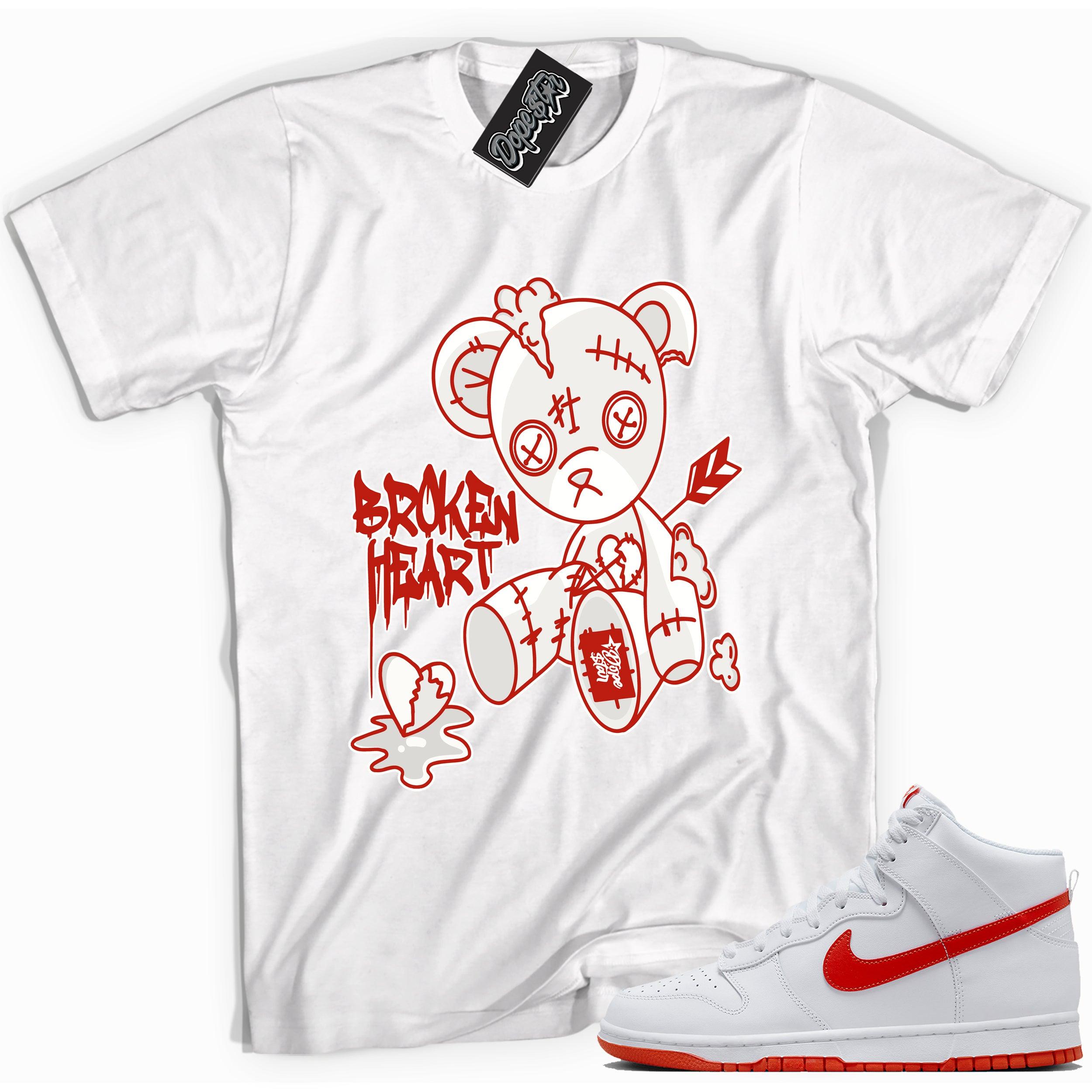 Cool white graphic tee with 'broken heart bear' print, that perfectly matches Nike Dunk High White Picante Red sneakers.