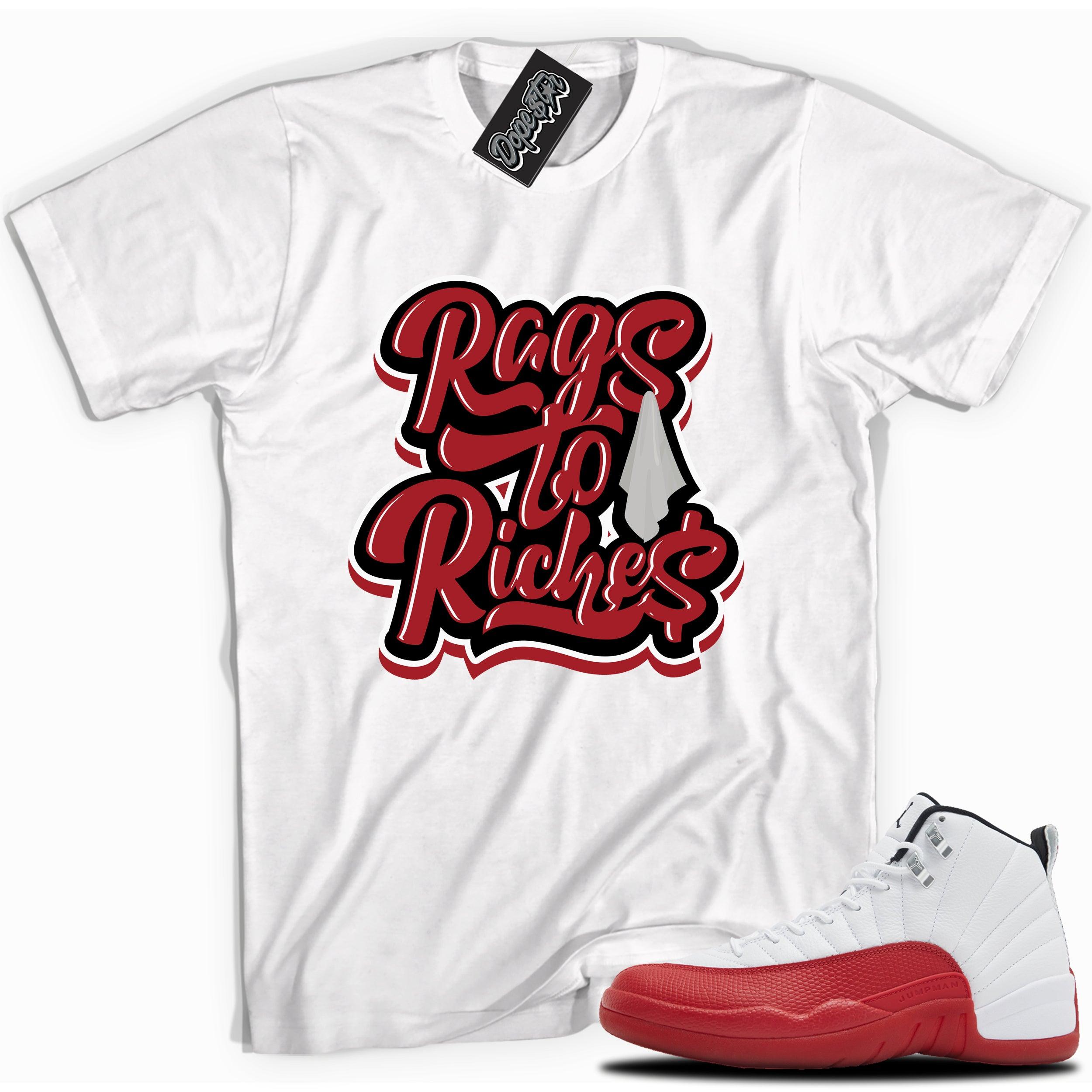 Cool White graphic tee with “Rags To Riches” print, that perfectly matches Air Jordan 12 Retro Cherry Red 2023 red and white sneakers