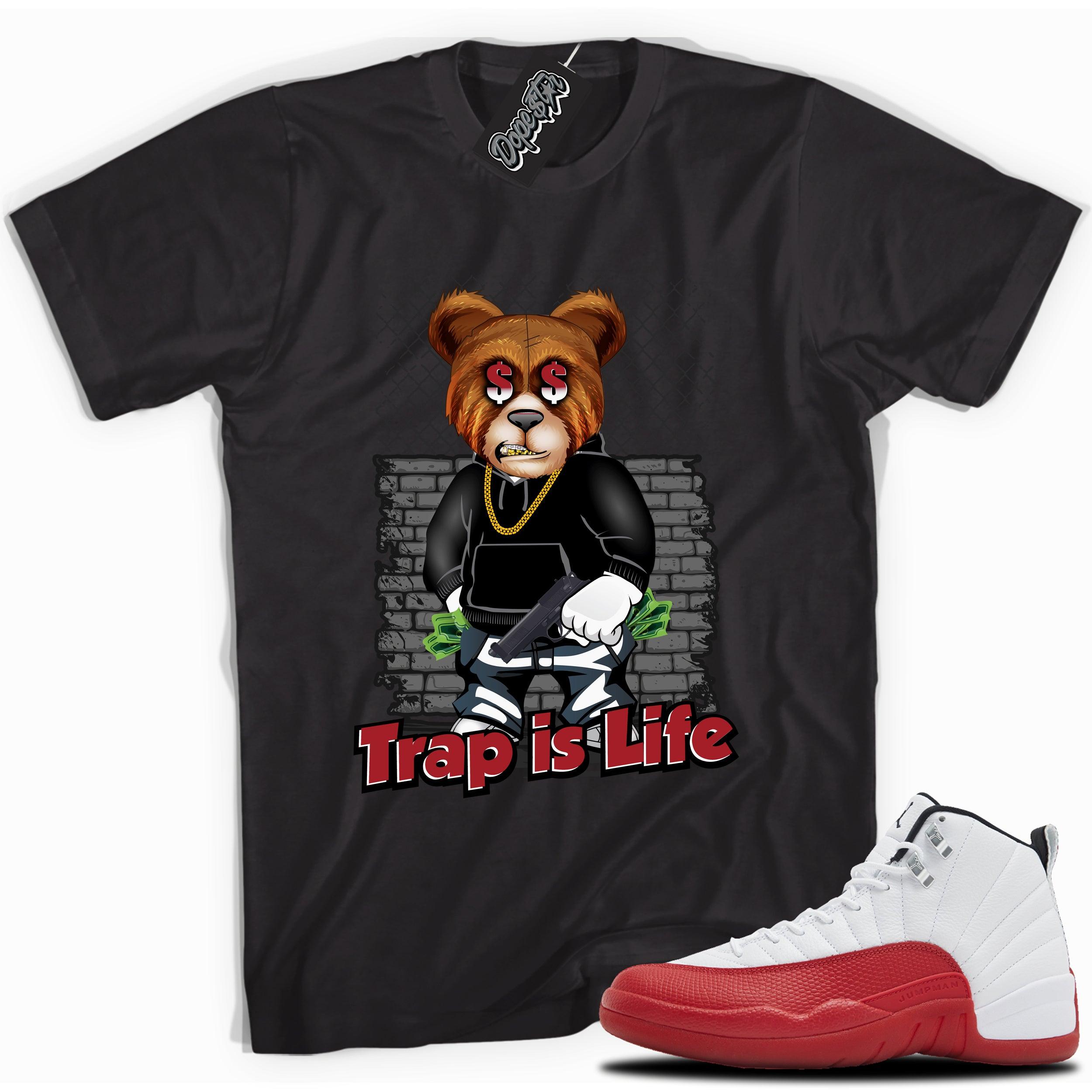 Cool Black graphic tee with “Trap Is Life” print, that perfectly matches Air Jordan 12 Retro Cherry Red 2023 red and white sneakers 