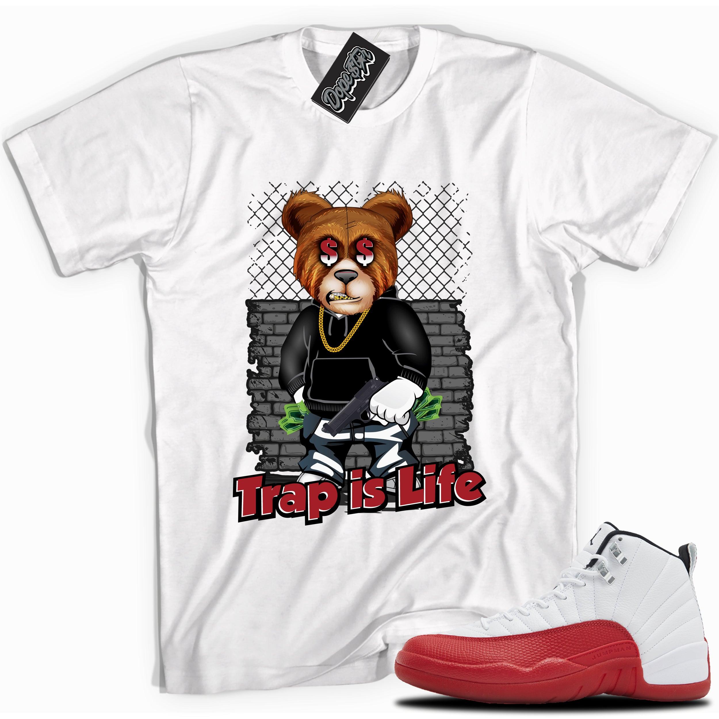 Cool White graphic tee with “Trap Is Life” print, that perfectly matches Air Jordan 12 Retro Cherry Red 2023 red and white sneakers 