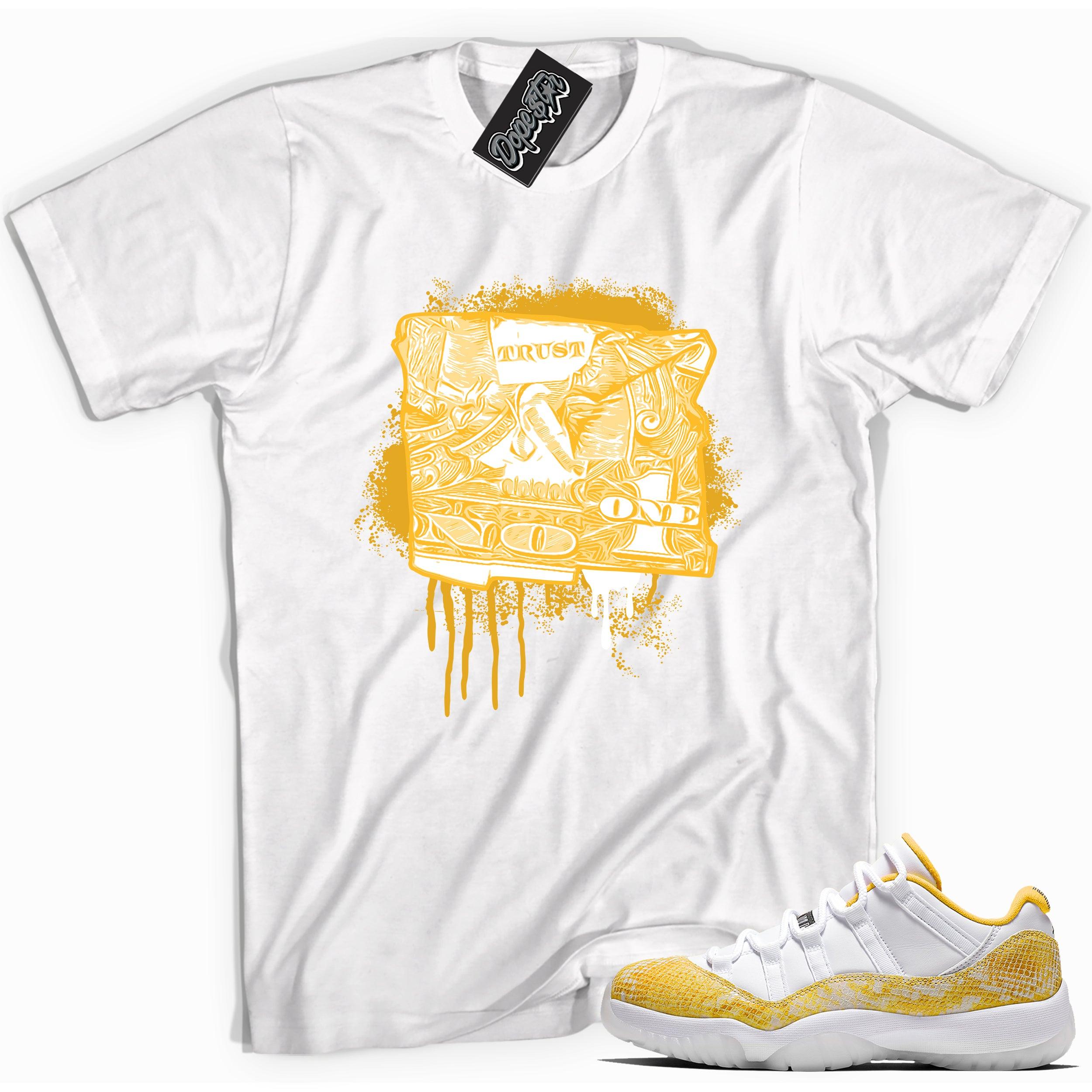 Cool white graphic tee with 'trust no one dollar bill' print, that perfectly matches Air Jordan 11 Retro Low Yellow Snakeskin sneakers