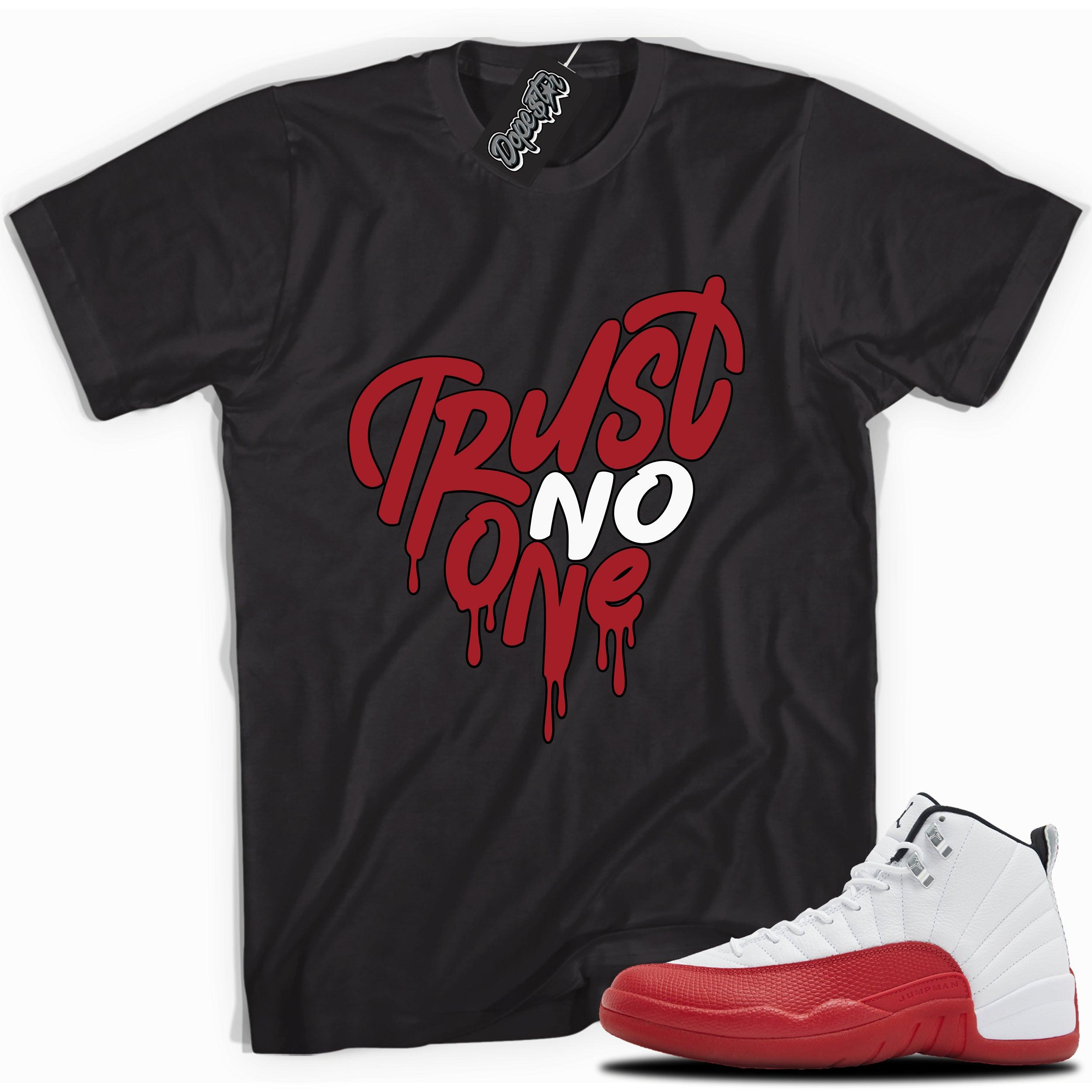 Cool black graphic tee with “Trust No One Heart” print, that perfectly matches Air Jordan 12 Retro Cherry Red 2023 red and white sneakers 