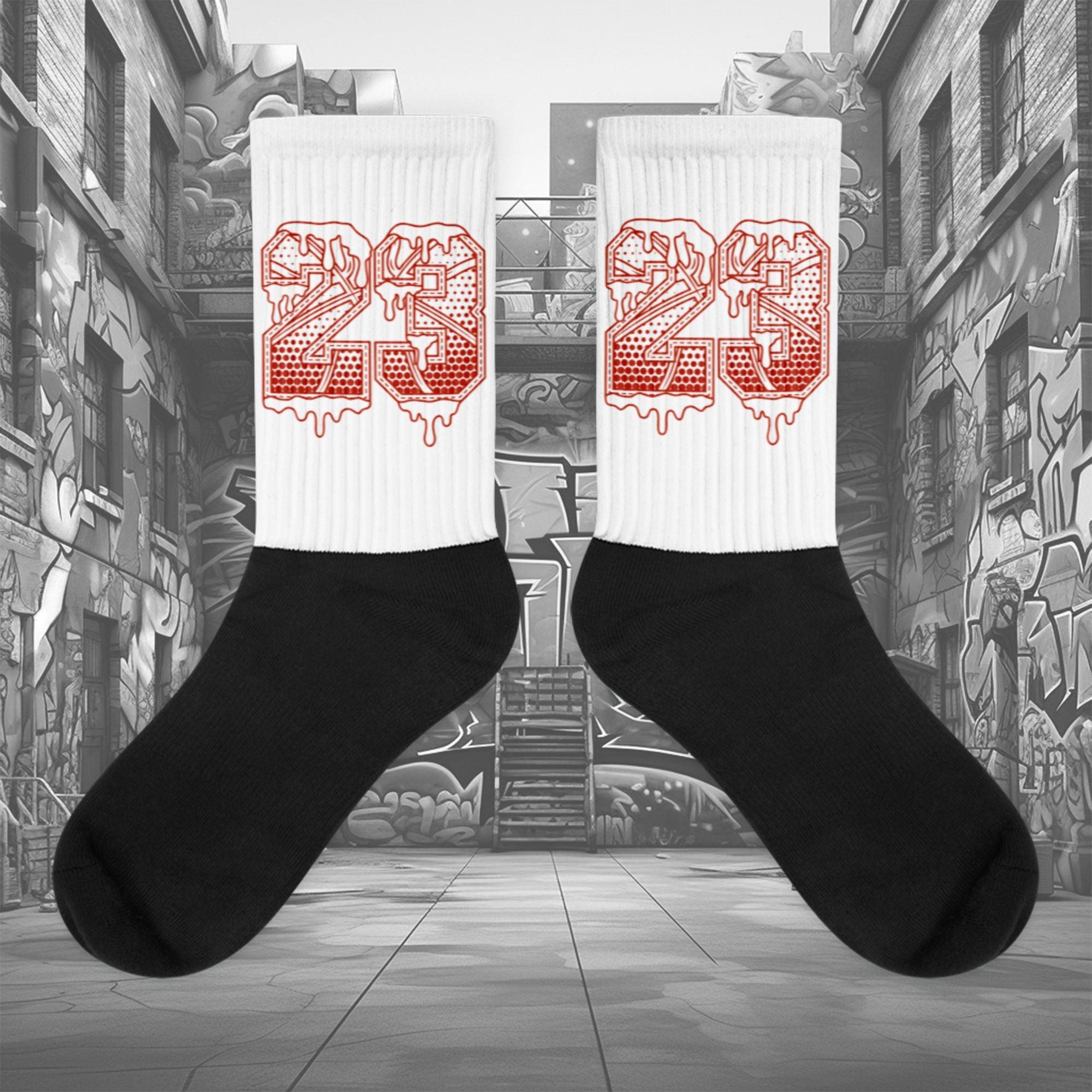  Showcases the view of the socks, highlighting the vibrant ' 23 Ball ' design, which perfectly complements the Air Jordan 11 Cherry sneakers. The intricate pattern and color scheme inspired by the  theme are prominently displayed.  Focusing on the ribbed leg , cusioned bottoms and the snug fit of the socks. This angle provides a clear view of the texture and quality of the material blend