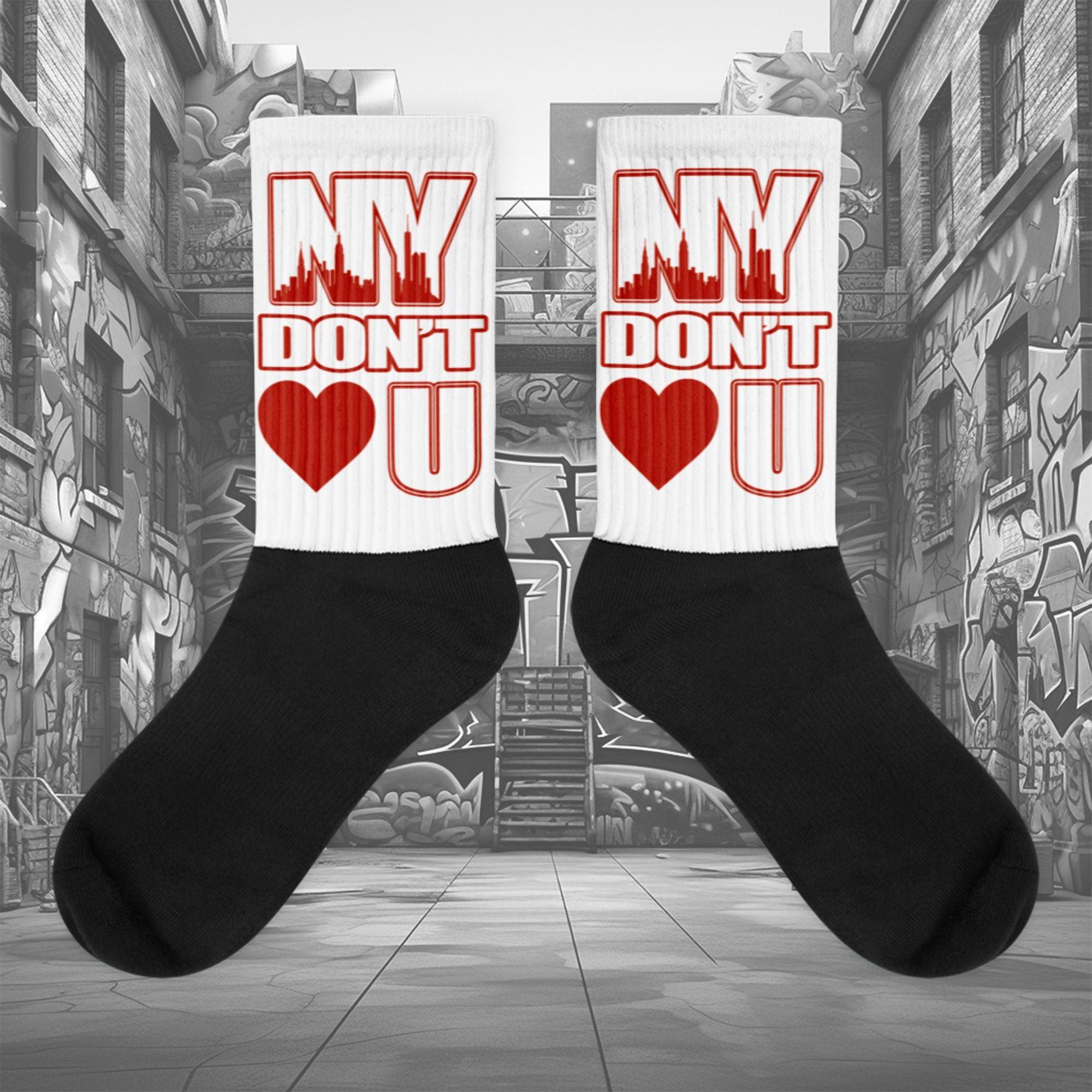 Showcases the view of the socks, highlighting the vibrant ' NY Don’t Love U ' design, which perfectly complements the Air Jordan 11 Cherry sneakers. The intricate pattern and color scheme inspired by the  theme are prominently displayed.  Focusing on the ribbed leg , cusioned bottoms and the snug fit of the socks. This angle provides a clear view of the texture and quality of the material blend.
