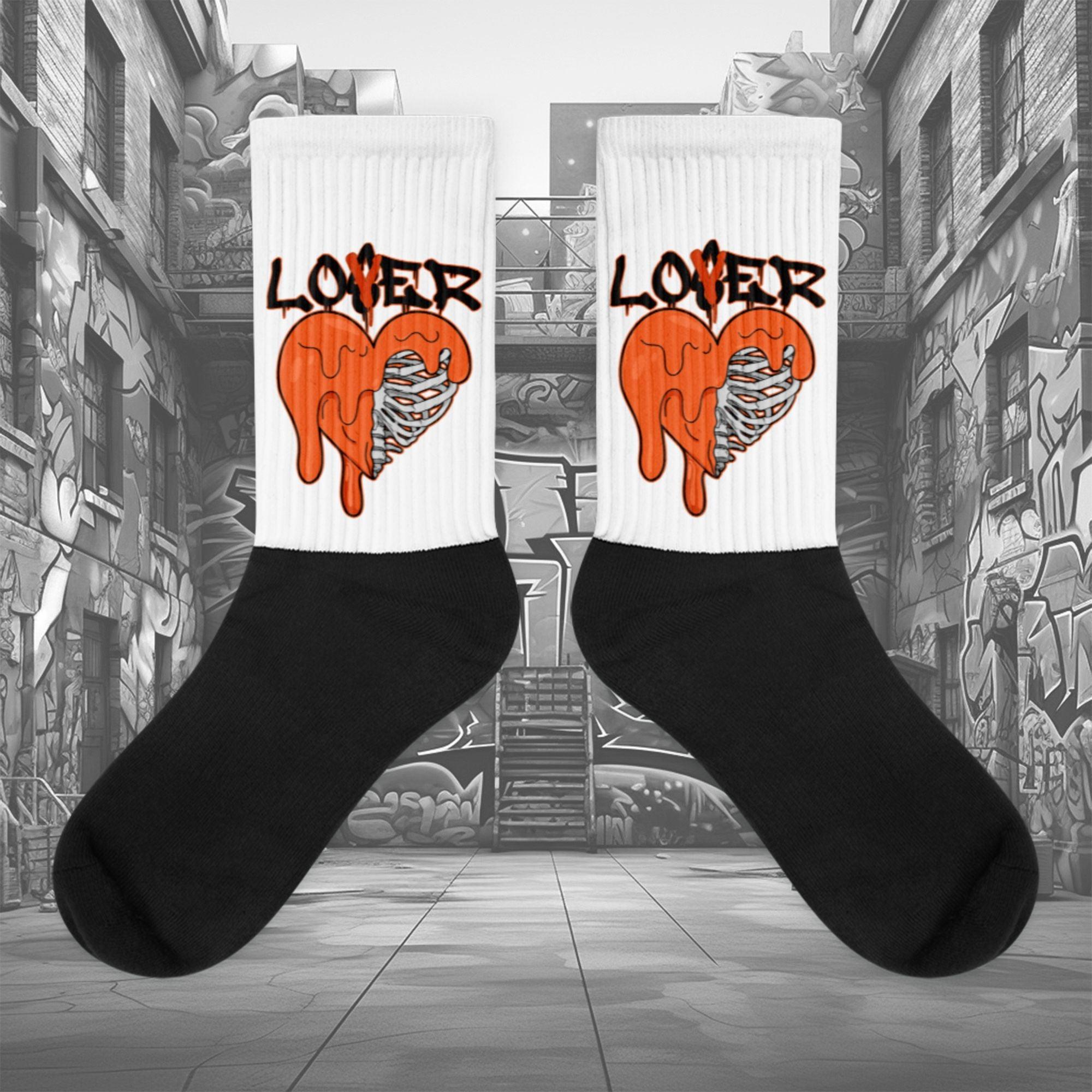  Showcases the view of the socks, highlighting the vibrant ' Lover Loser ‘ design, which perfectly complements the Air Jordan 12 Retro WNBA All-Star Brilliant Orange sneakers. The intricate pattern and color scheme inspired by the  theme are prominently displayed.  Focusing on the ribbed leg , cusioned bottoms and the snug fit of the socks. This angle provides a clear view of the texture and quality of the material blend.