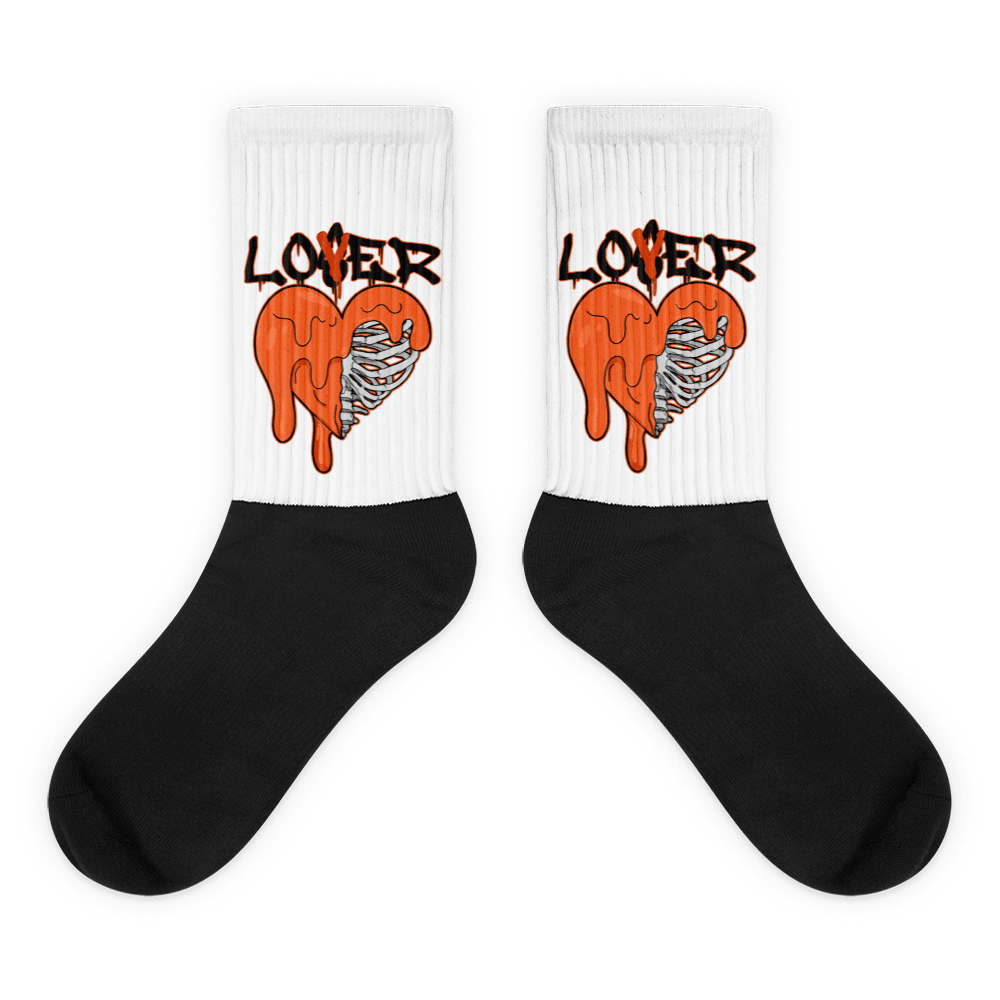  Showcases the view of the socks, highlighting the vibrant ' Lover Loser ‘ design, which perfectly complements the Air Jordan 12 Retro WNBA All-Star Brilliant Orange sneakers. The intricate pattern and color scheme inspired by the  theme are prominently displayed.  Focusing on the ribbed leg , cusioned bottoms and the snug fit of the socks. This angle provides a clear view of the texture and quality of the material blend.