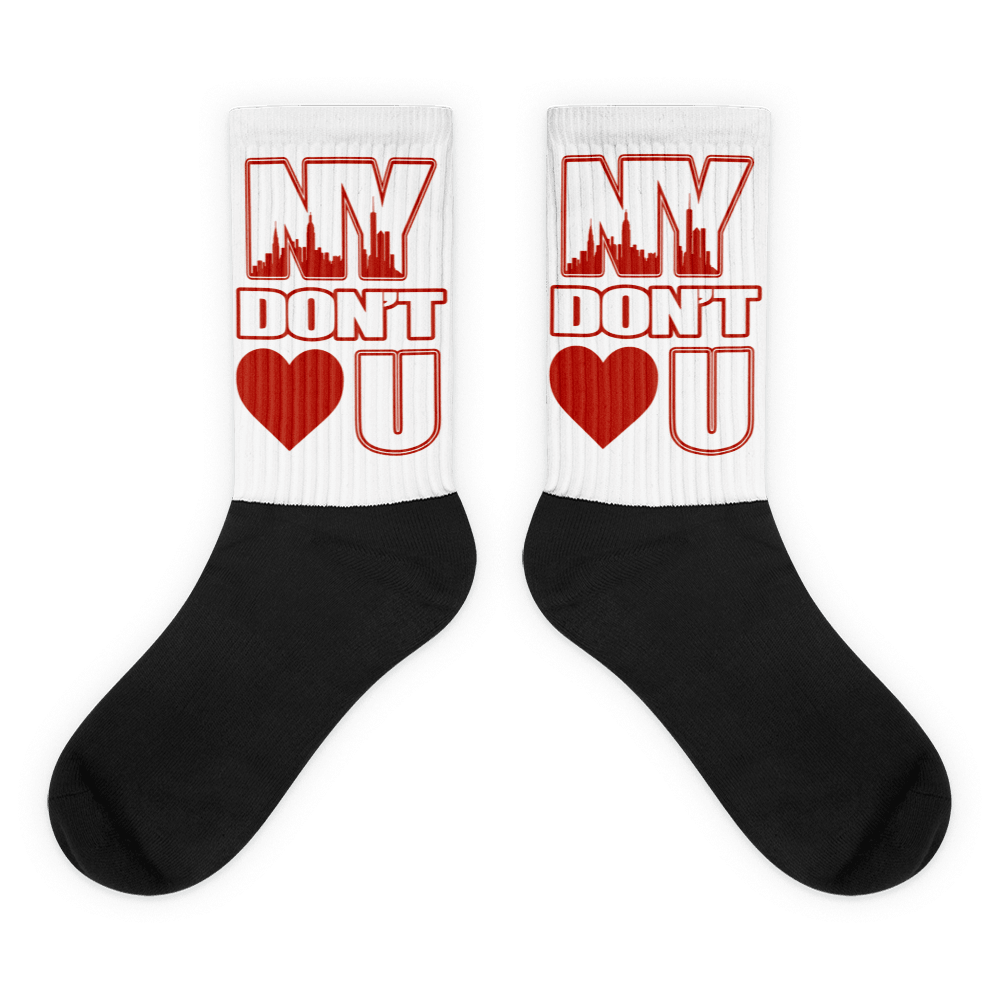  Showcases the view of the socks, highlighting the vibrant ' NY Don’t Love U ' design, which perfectly complements the Air Jordan 11 Cherry sneakers. The intricate pattern and color scheme inspired by the  theme are prominently displayed.  Focusing on the ribbed leg , cusioned bottoms and the snug fit of the socks. This angle provides a clear view of the texture and quality of the material blend.